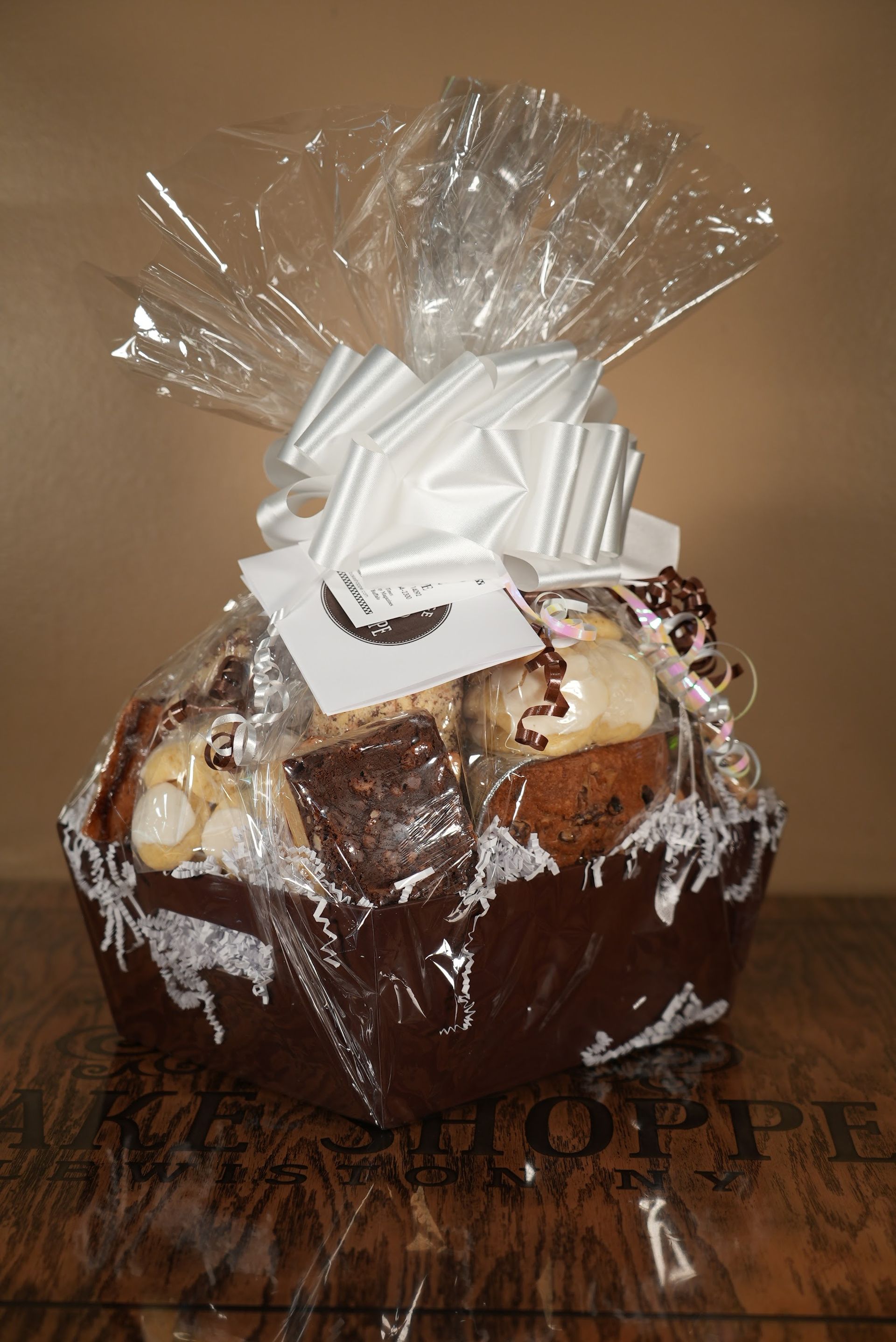 a basket filled with a variety of cookies and brownies is sitting on a wooden table .
