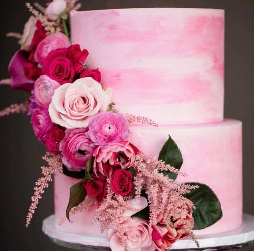 a pink cake with pink flowers on top of it