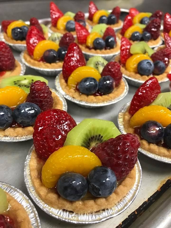 a bunch of fruit tarts are sitting on a table .
