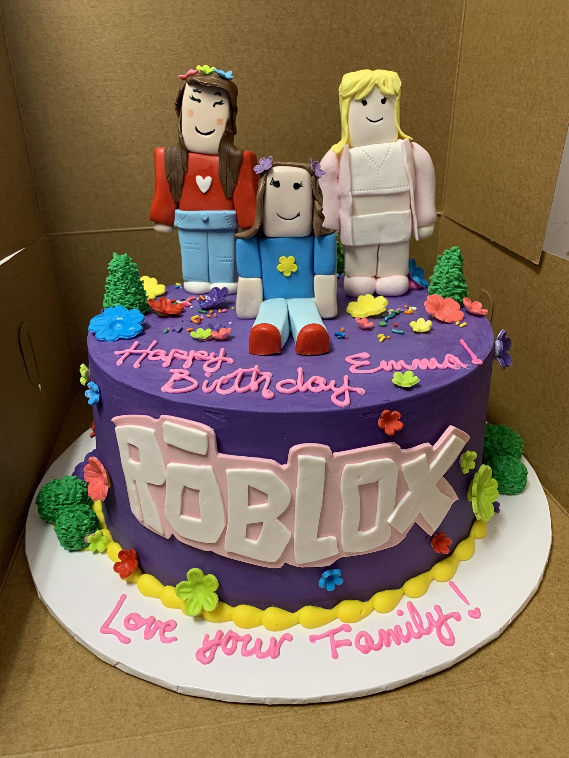 a purple cake with roblox characters on it