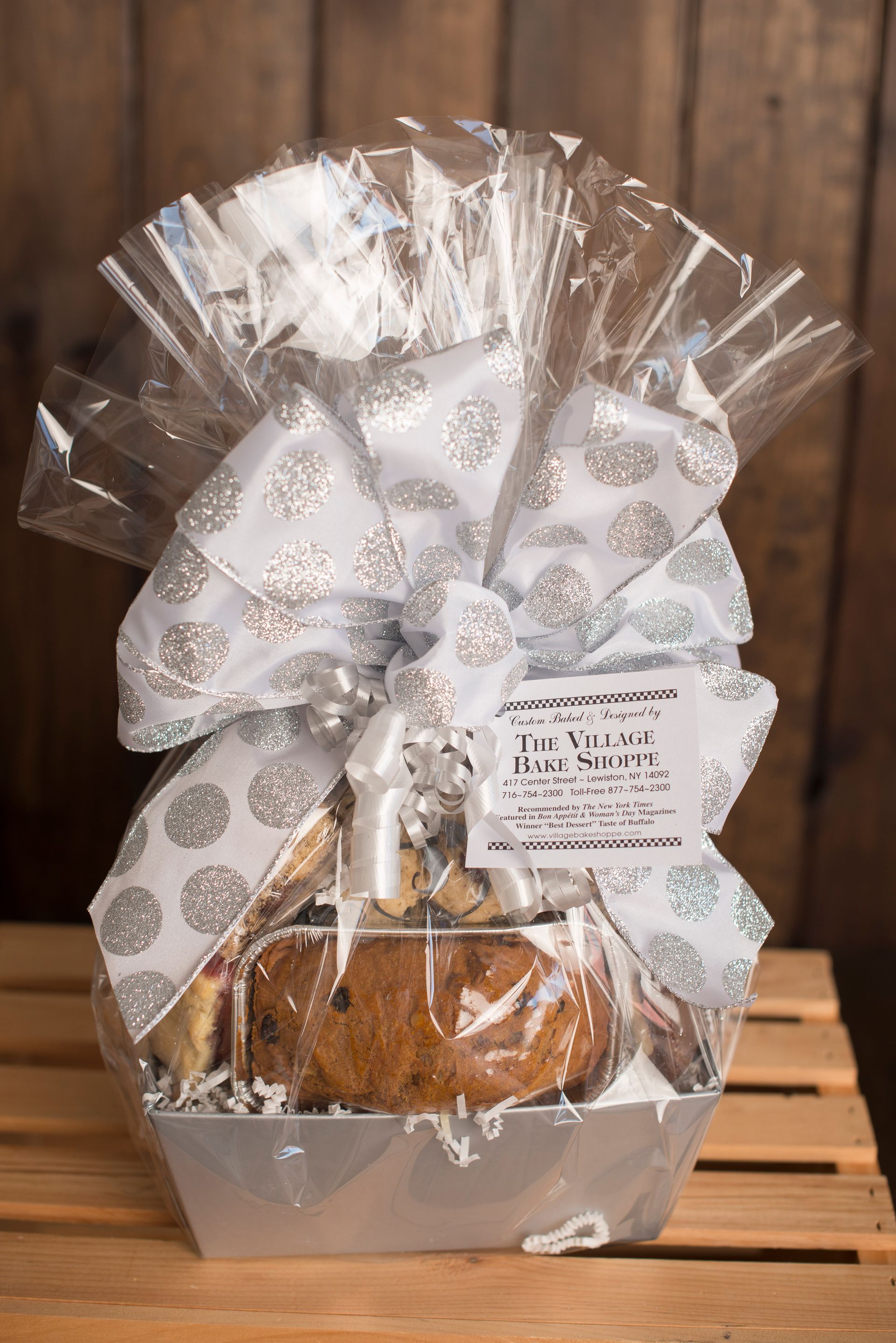 a basket filled with cookies and a bow is sitting on a wooden table .