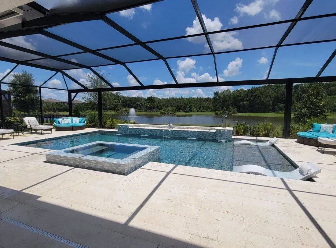 There is a large swimming pool with a hot tub in the middle of it.