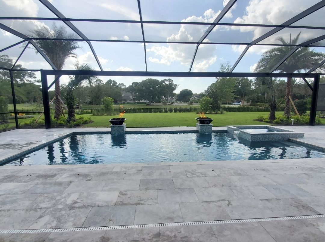 A large swimming pool with a screened in area surrounding it
