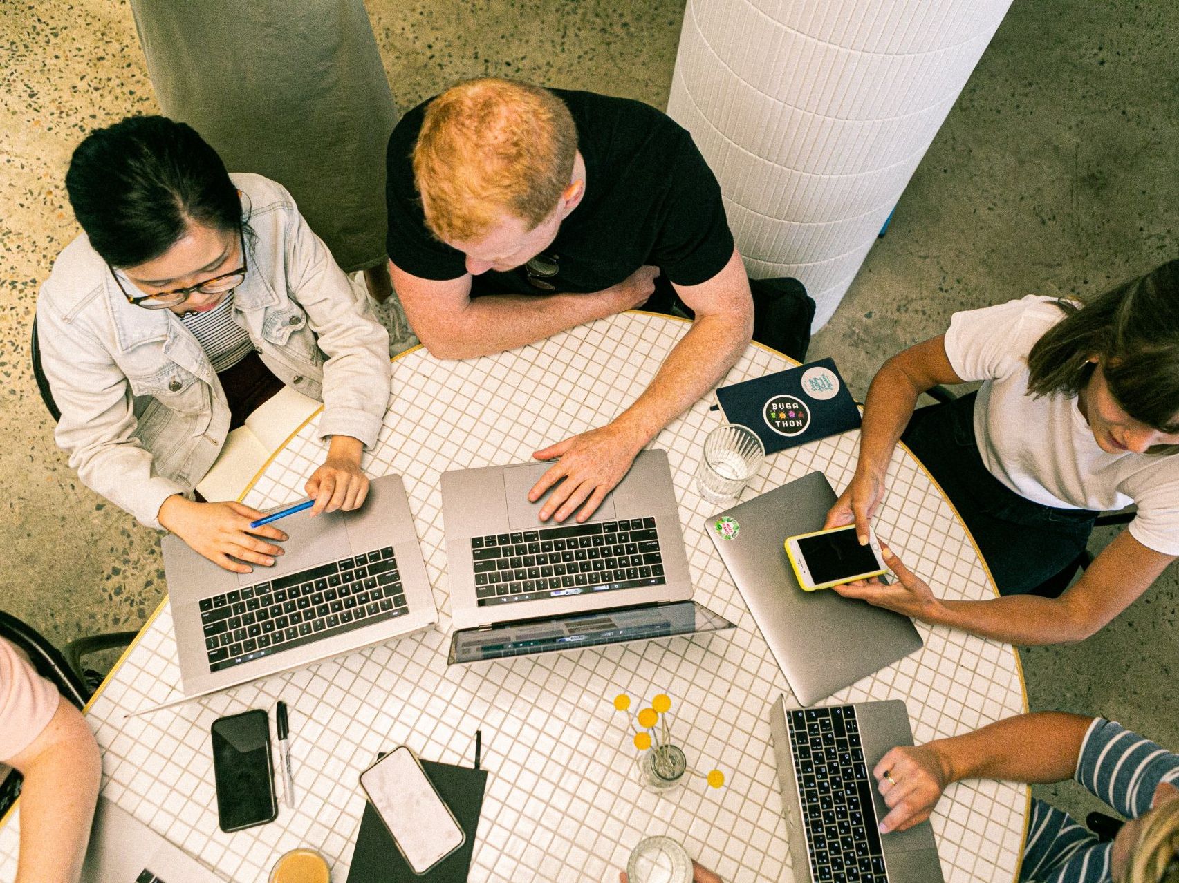 People sitting around a table working on laptops