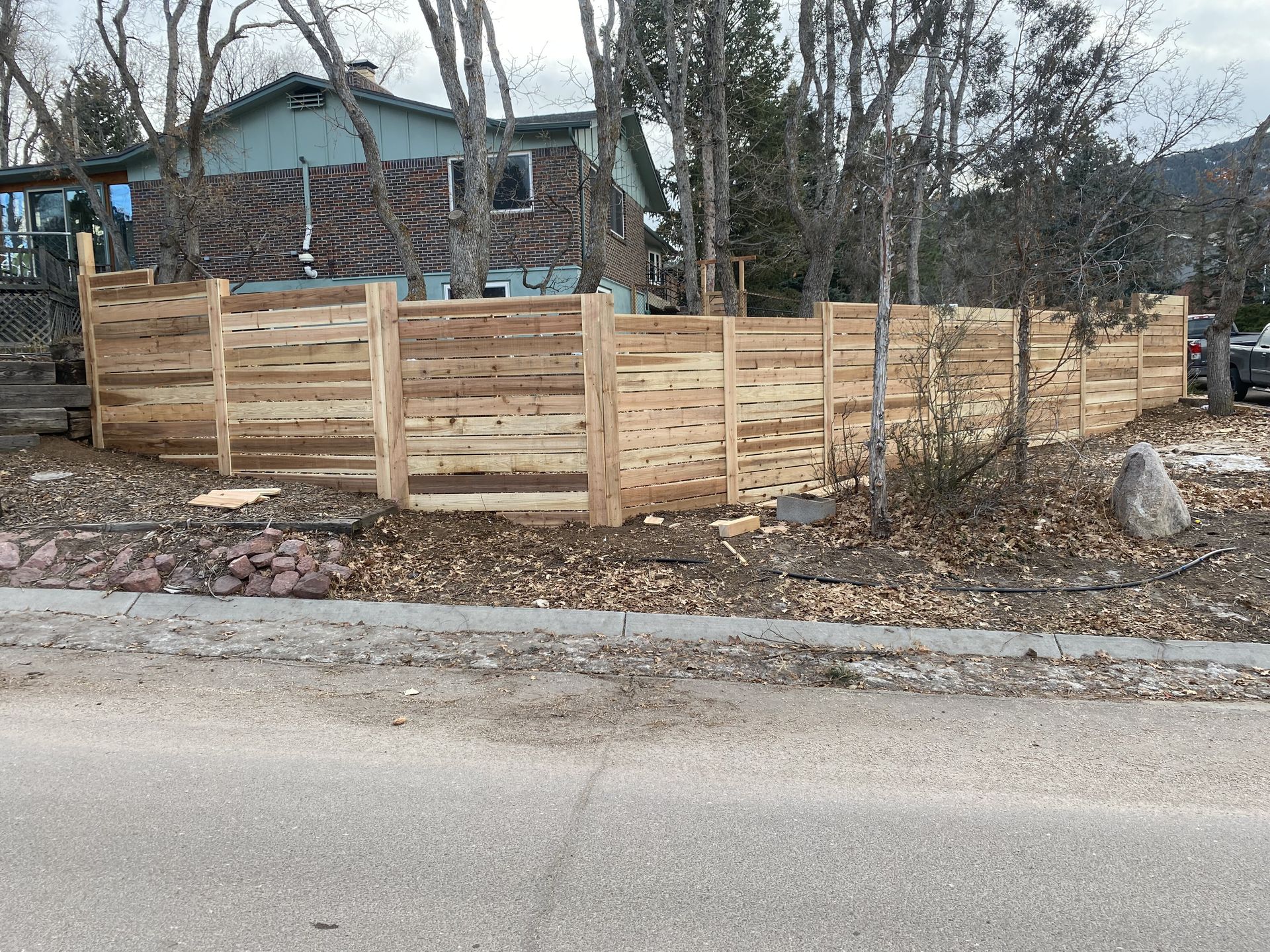 A wooden fence is being built in front of a house.