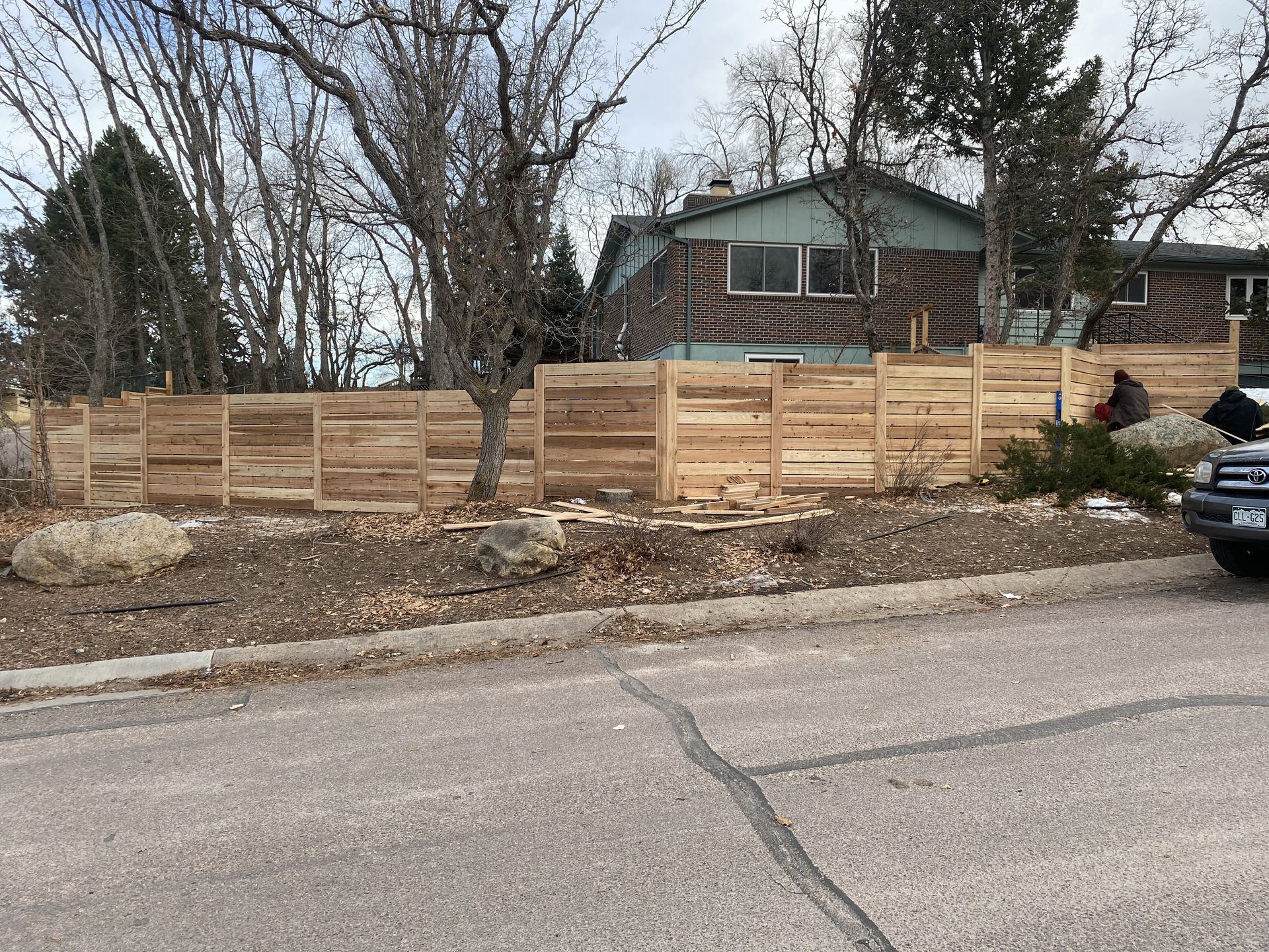 A wooden fence is being built in front of a house.