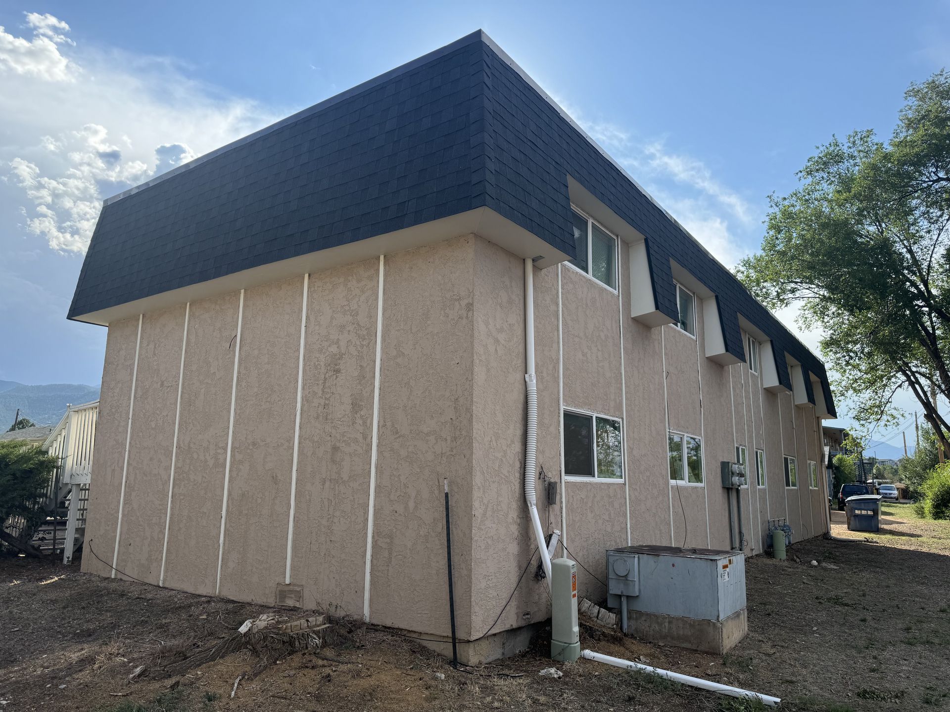 A large building with a lot of windows and a black roof.