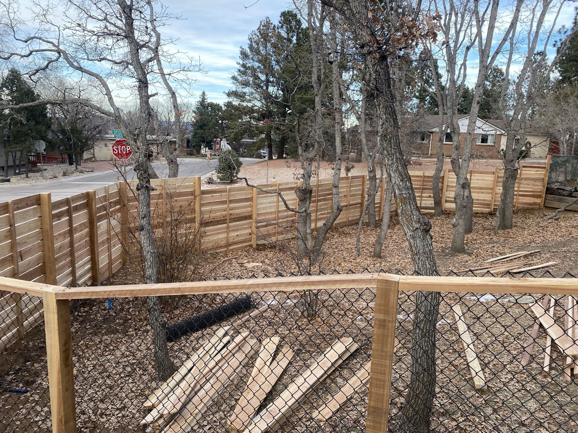 A wooden fence is being built in the middle of a forest.