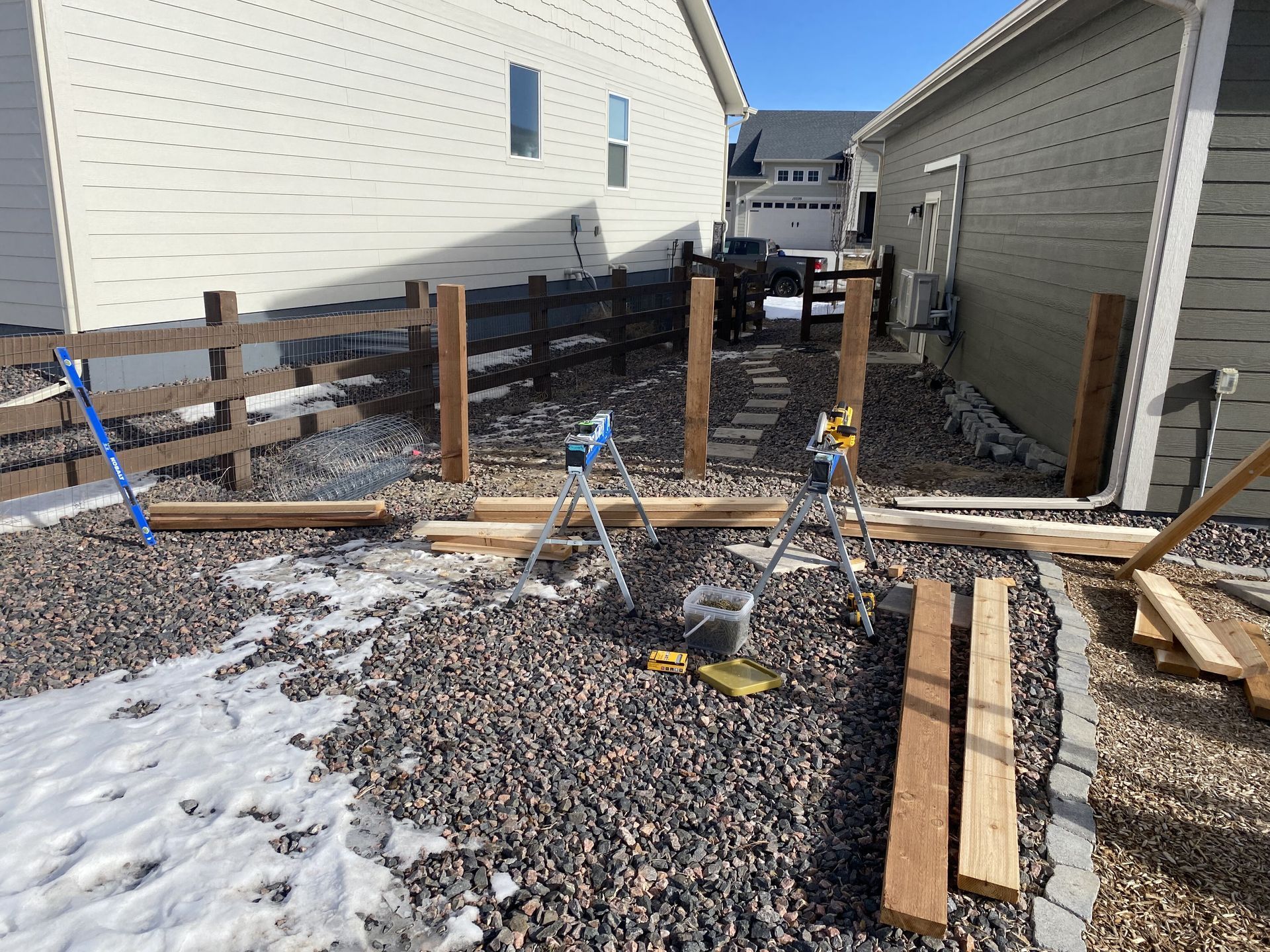 A wooden fence is being built in front of a house.