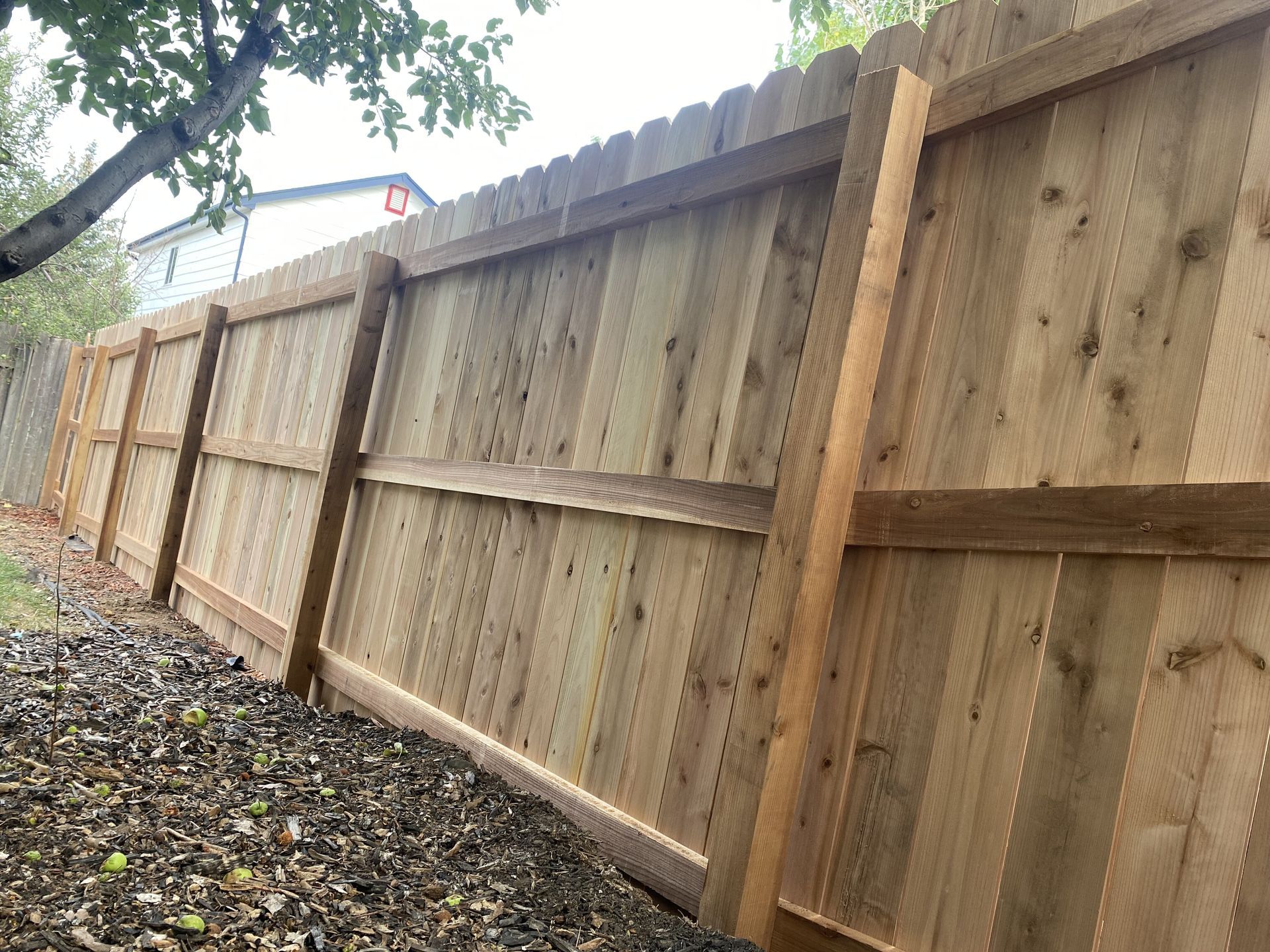 A wooden fence is sitting on top of a pile of leaves.