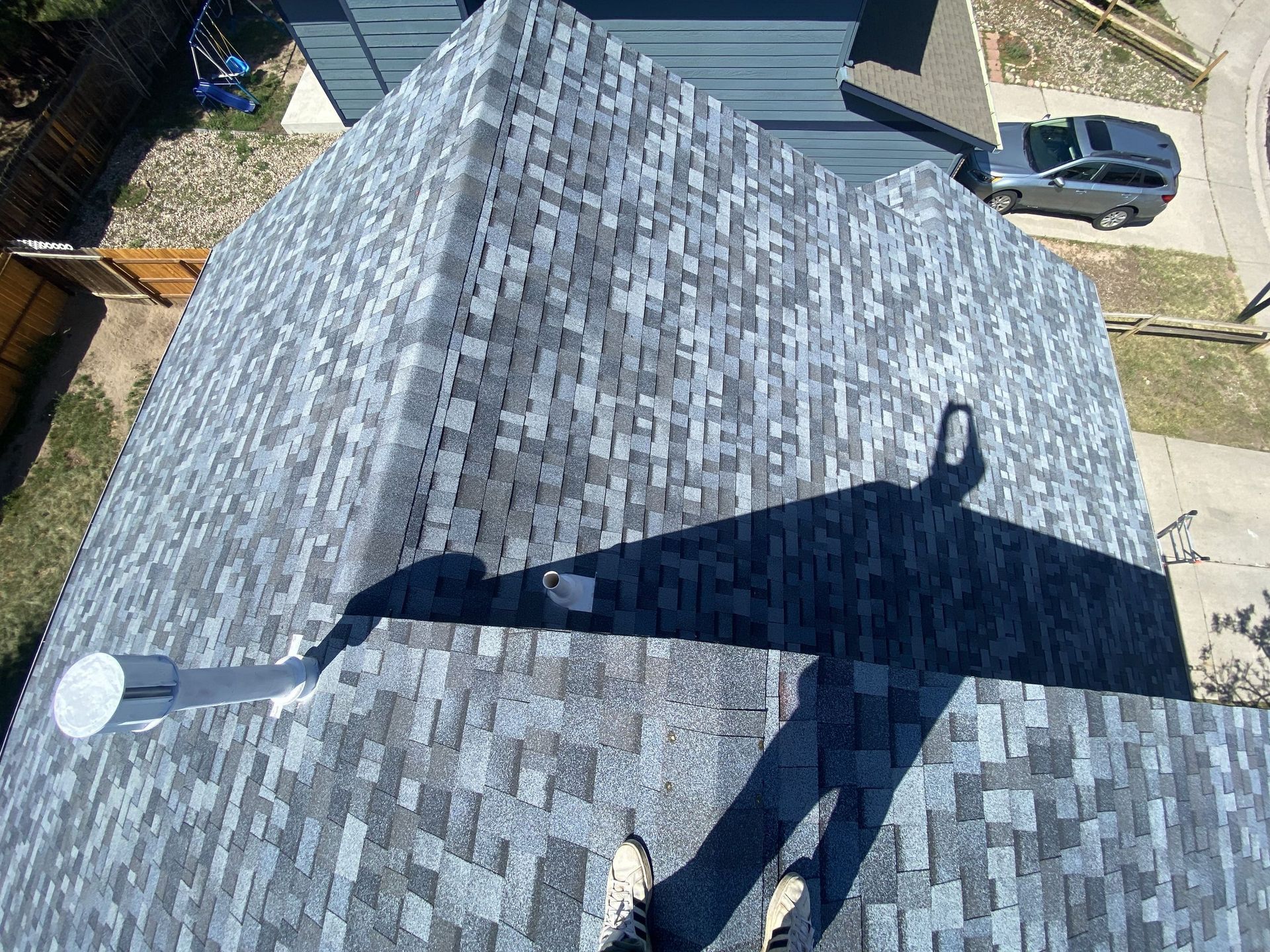 A person is standing on the roof of a house.