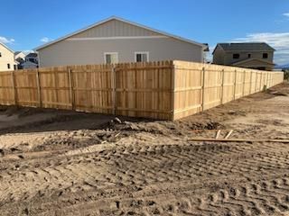 A wooden fence is being built in front of a house.