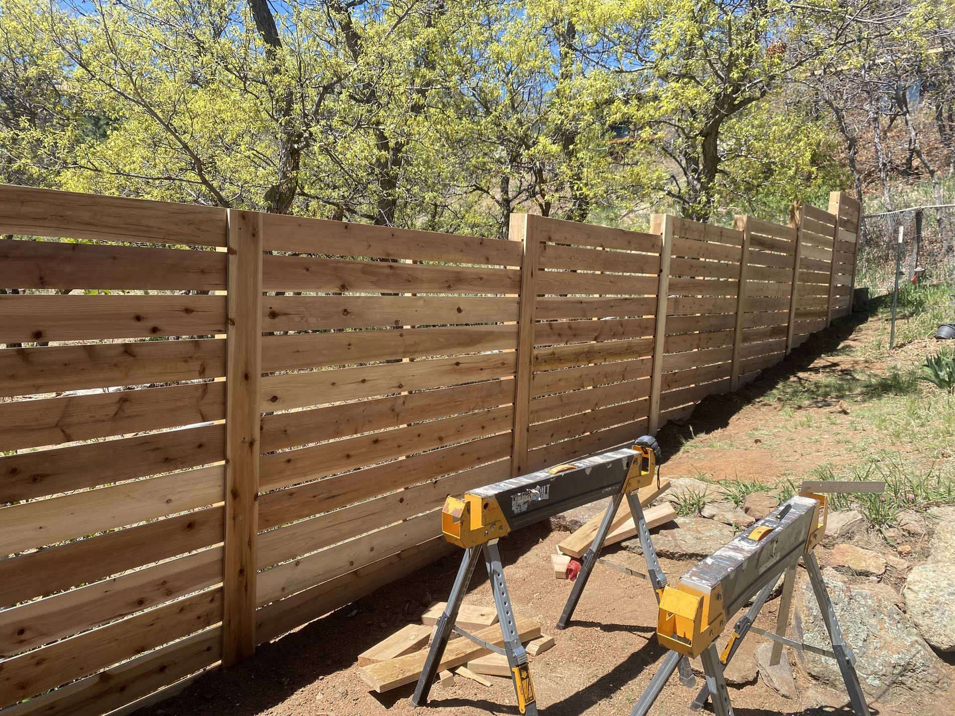 A wooden fence is being built in a backyard.