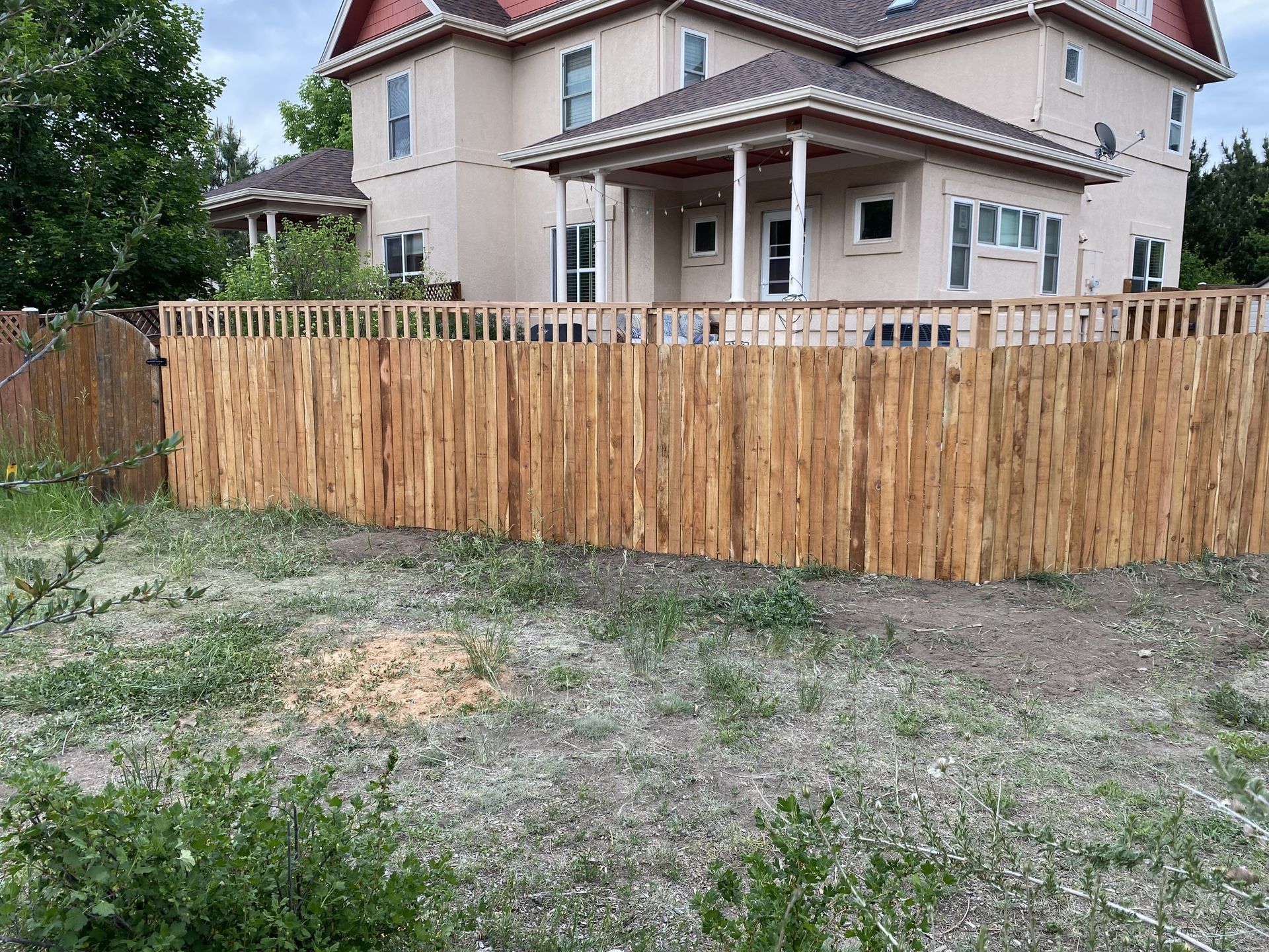 A large house with a wooden fence in front of it.