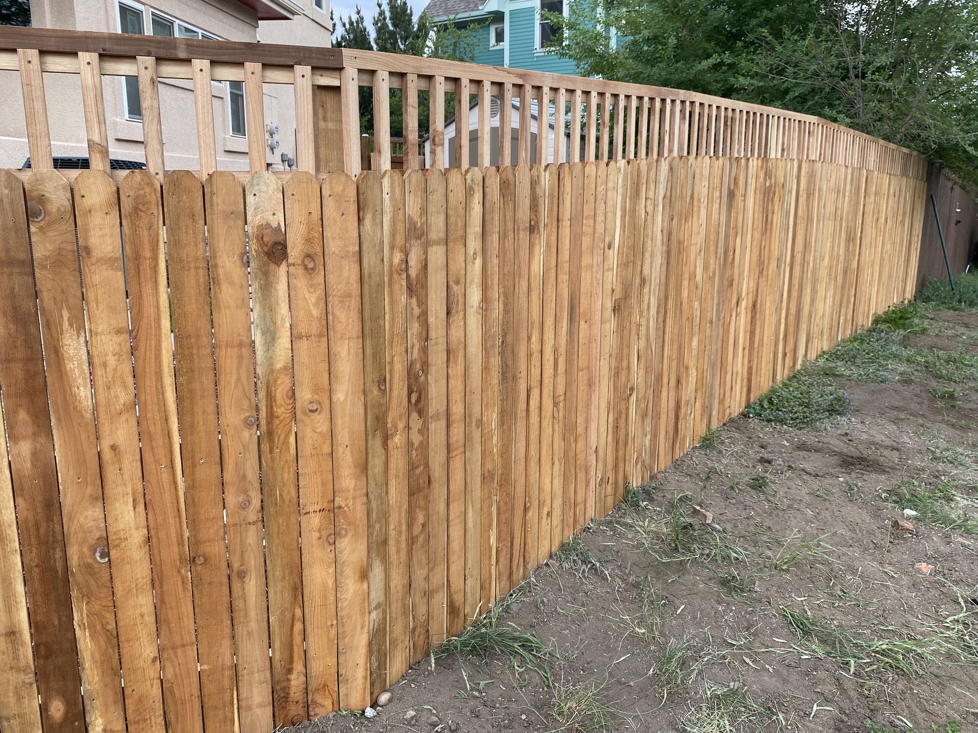 A wooden fence is sitting on top of a dirt field.