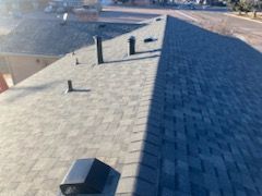 A roof with a lot of shingles and chimneys on it.