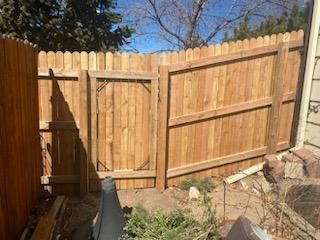 A wooden fence with a gate in the backyard.