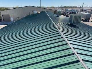 A green metal roof is sitting on top of a building.