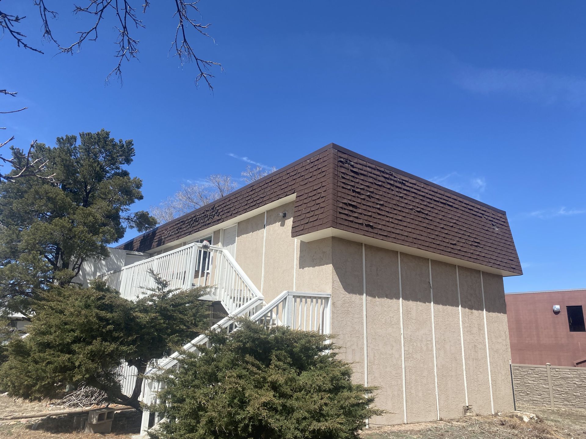 A building with stairs leading up to it and a blue sky in the background.