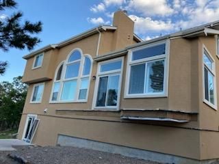 A large house with a lot of windows and a chimney.