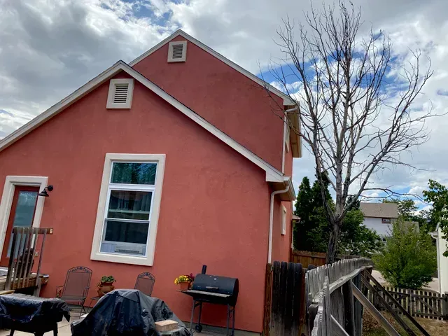 A red house with a grill in front of it