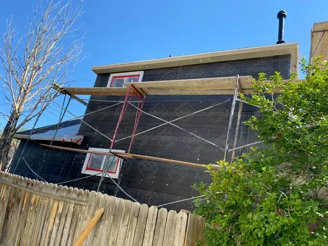 A house is being remodeled with scaffolding on the side of it.