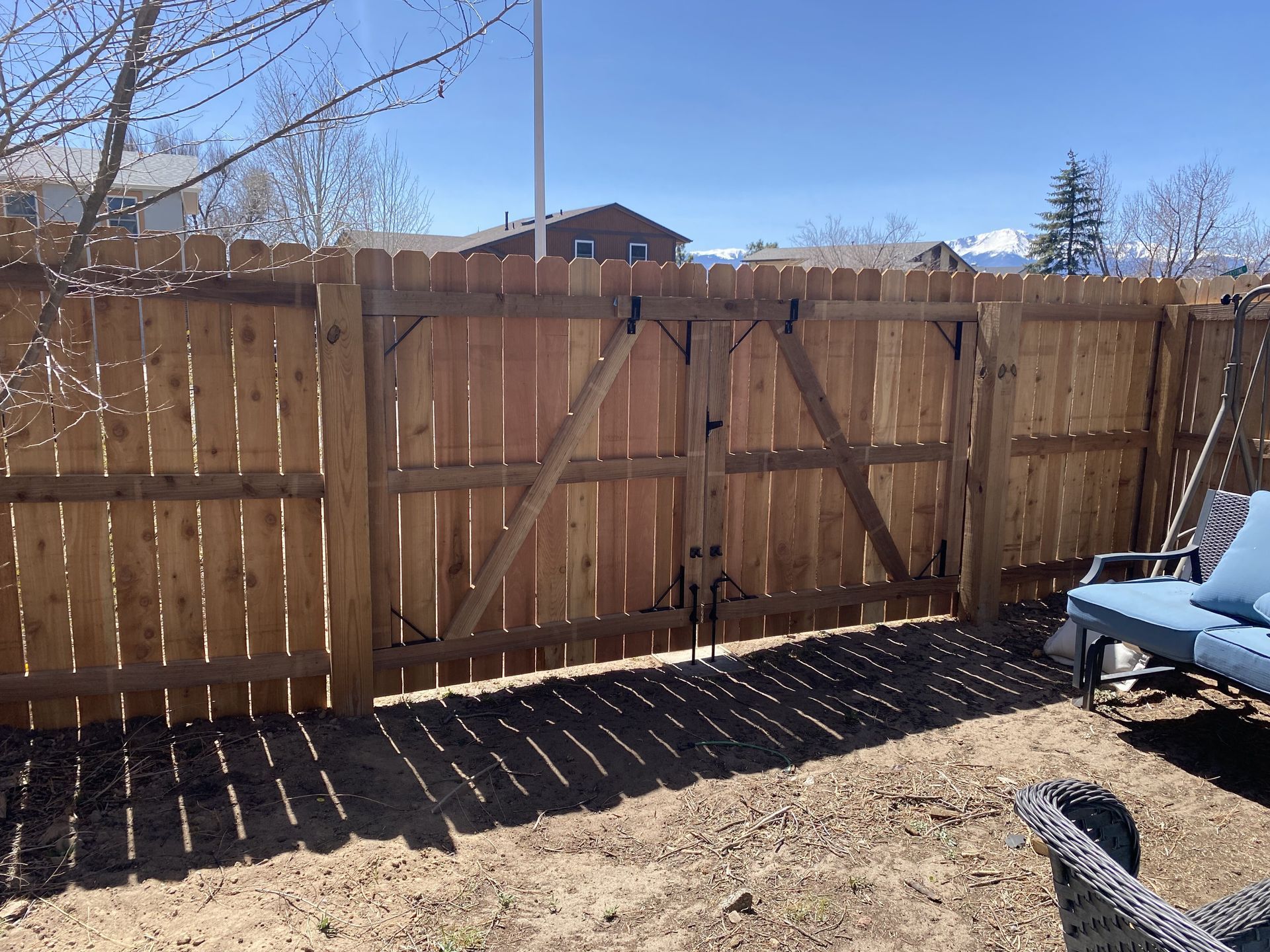 A wooden fence with a gate in the backyard.