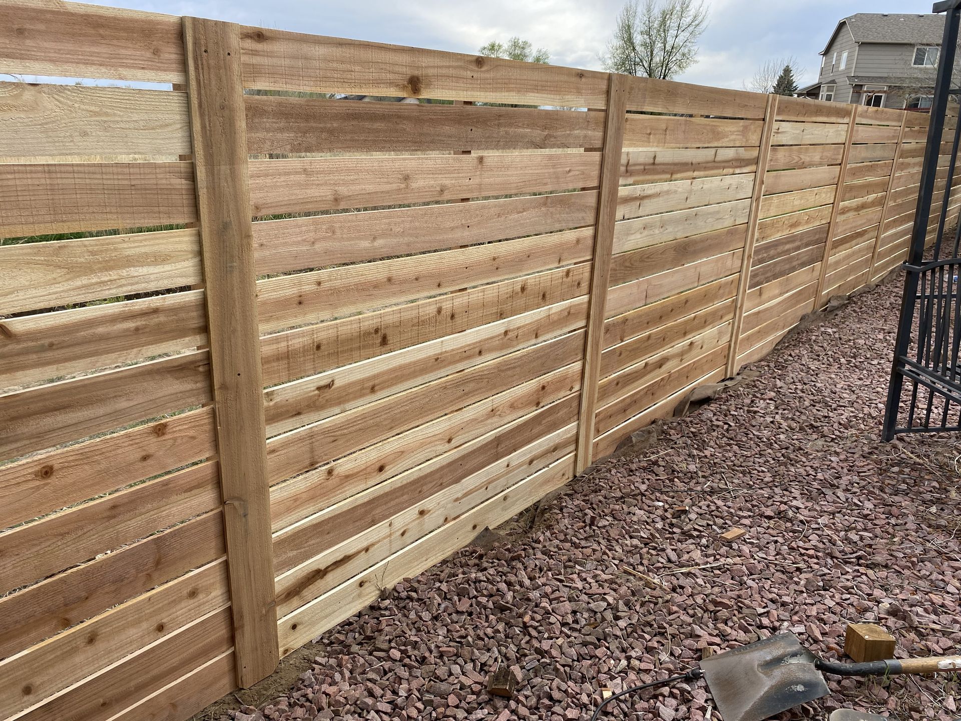 A wooden fence is sitting on top of a pile of gravel.