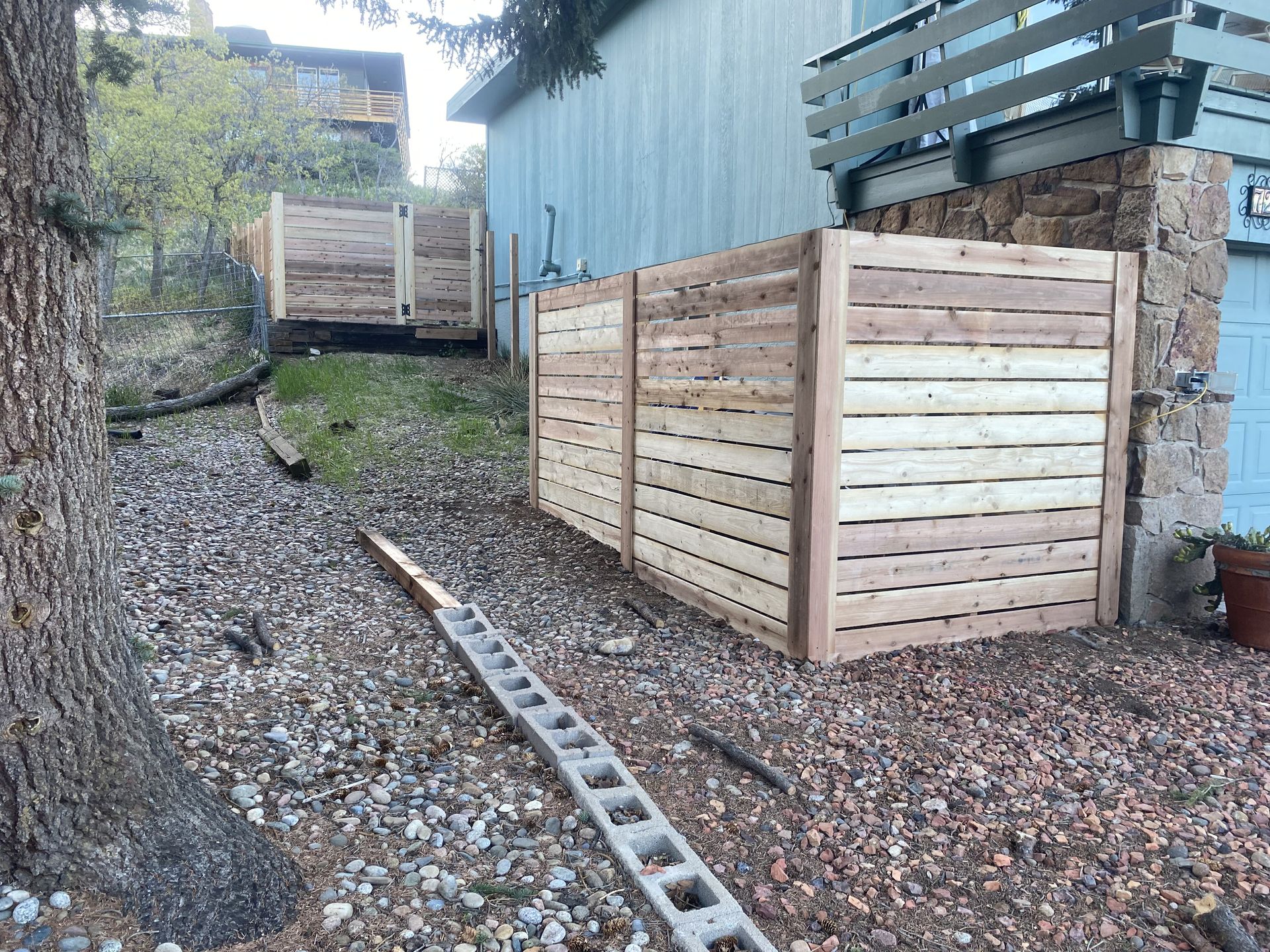 A wooden fence is being built in front of a house.