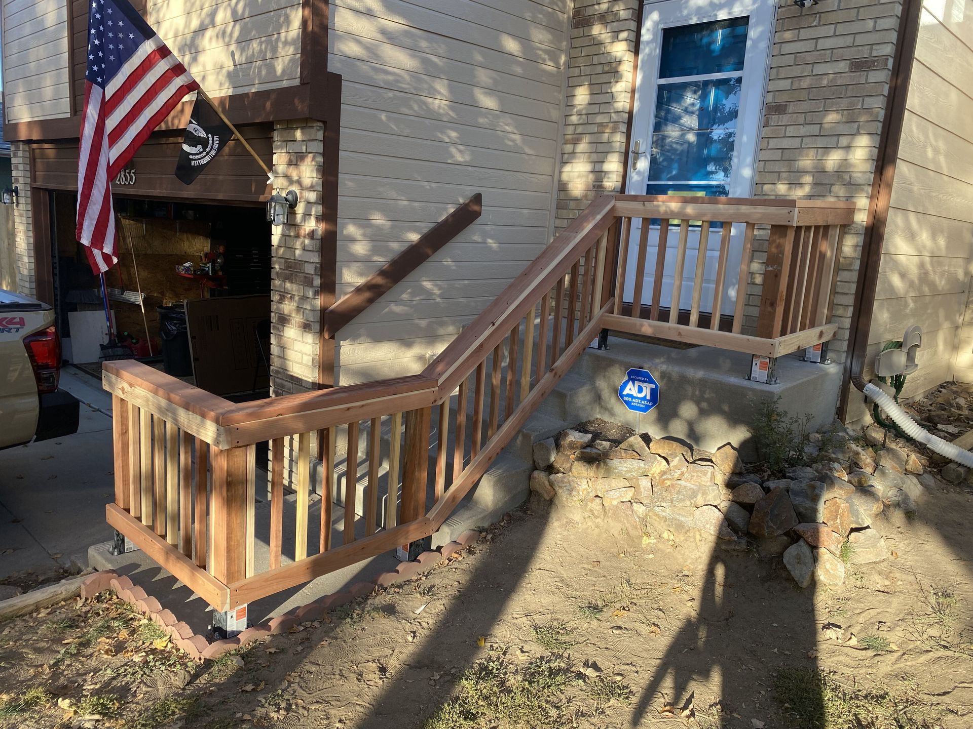 A wooden railing is attached to the side of a house.