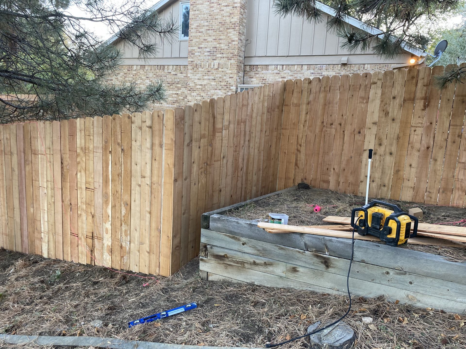 A wooden fence is being built in front of a house.