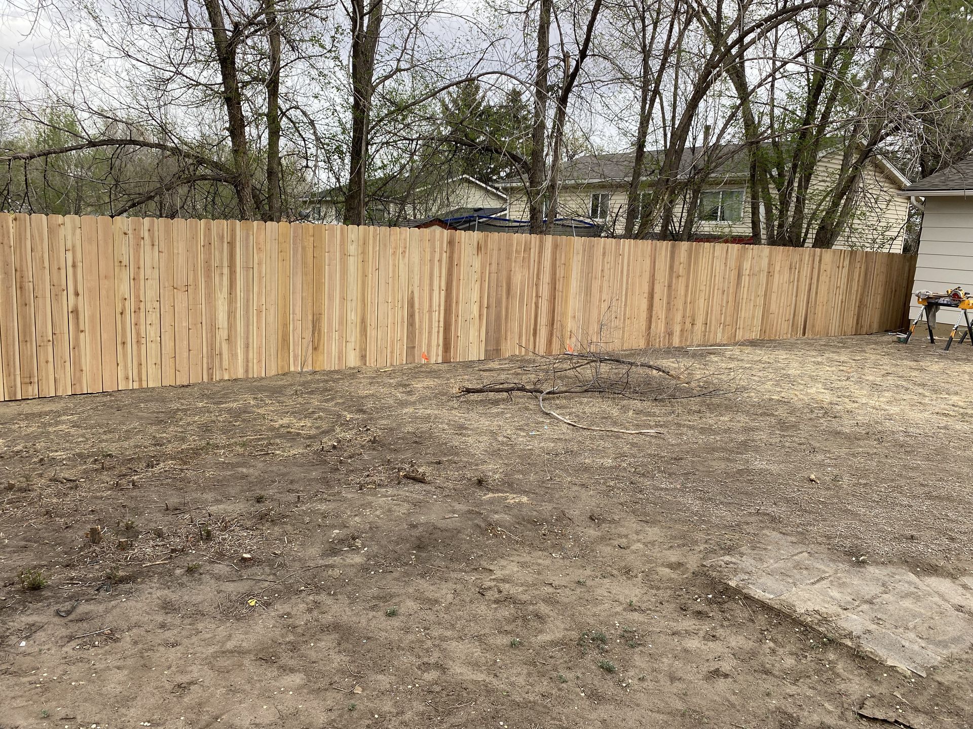 A wooden fence is sitting in the middle of a dirt field.