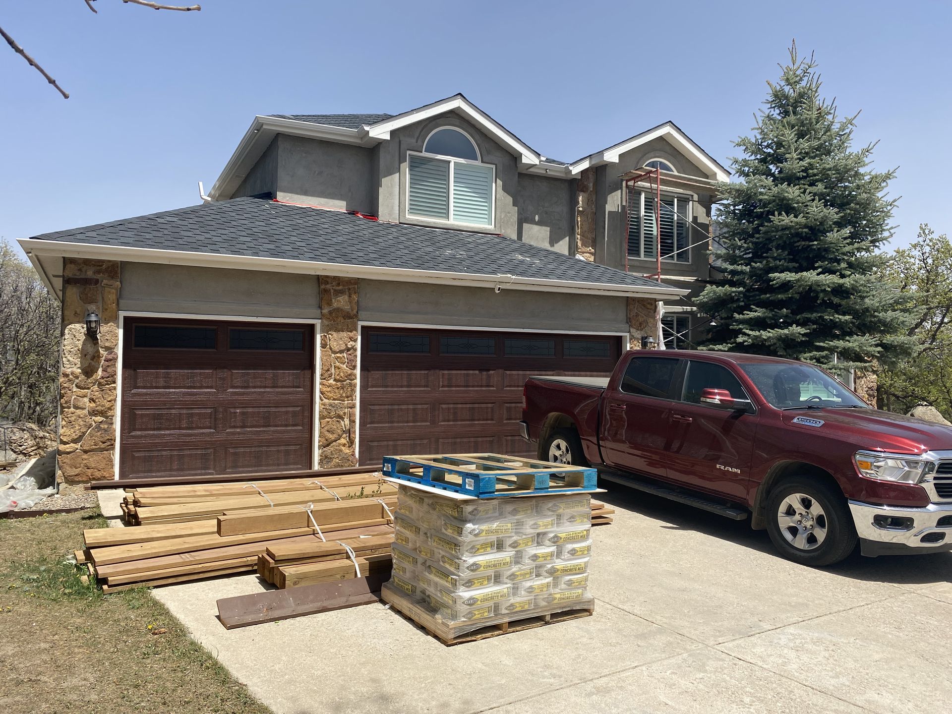 A red truck is parked in front of a large house.