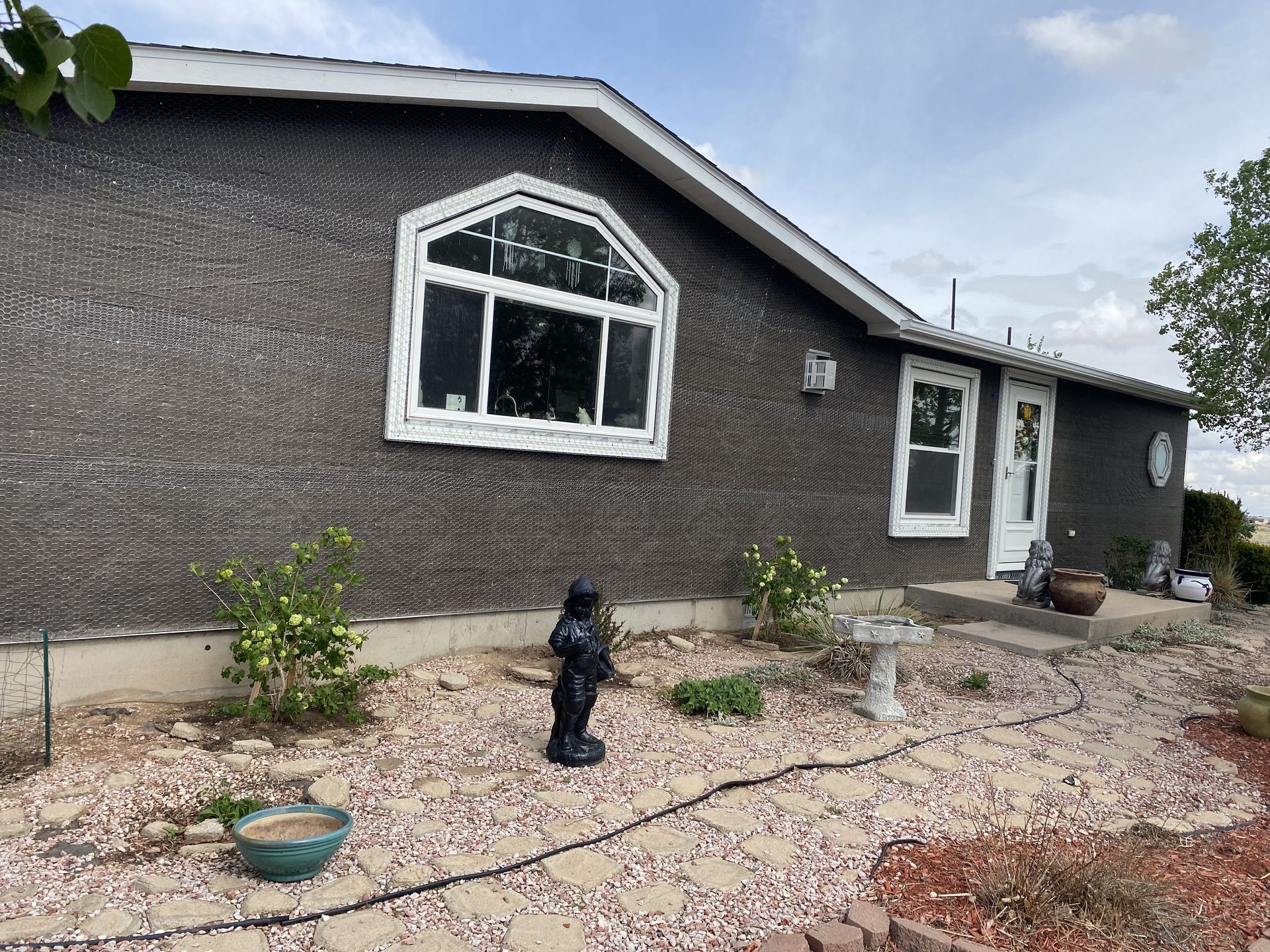 A house with a large window and a statue in front of it.