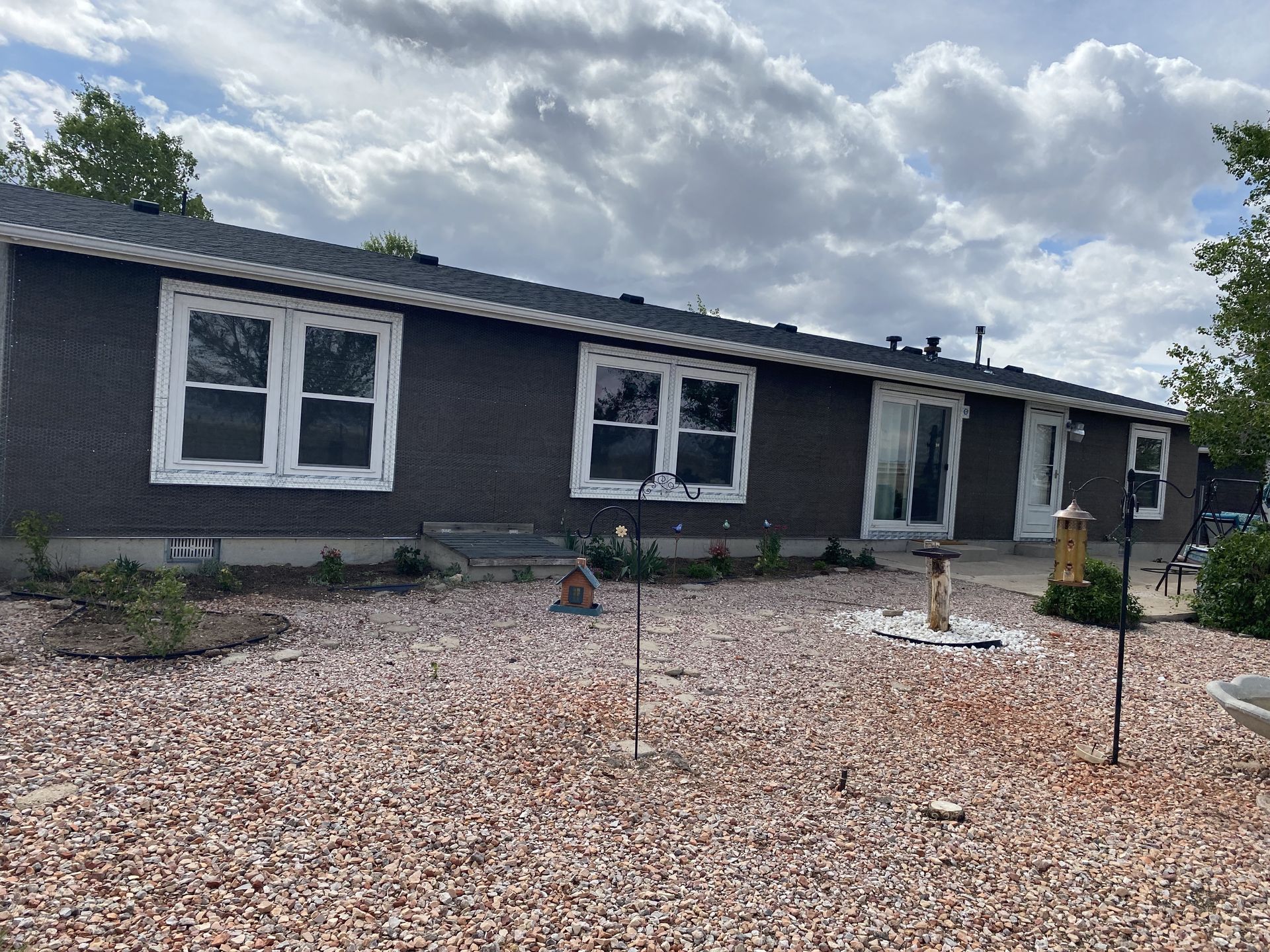 A mobile home with a lot of windows and gravel in front of it