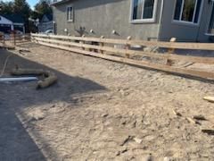 A wooden fence is being built in front of a house.