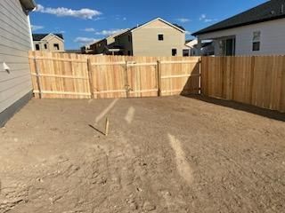 There is a wooden fence in the backyard of a house.