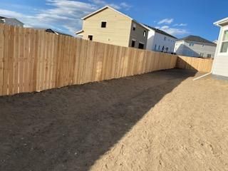 There is a wooden fence in the backyard of a house.