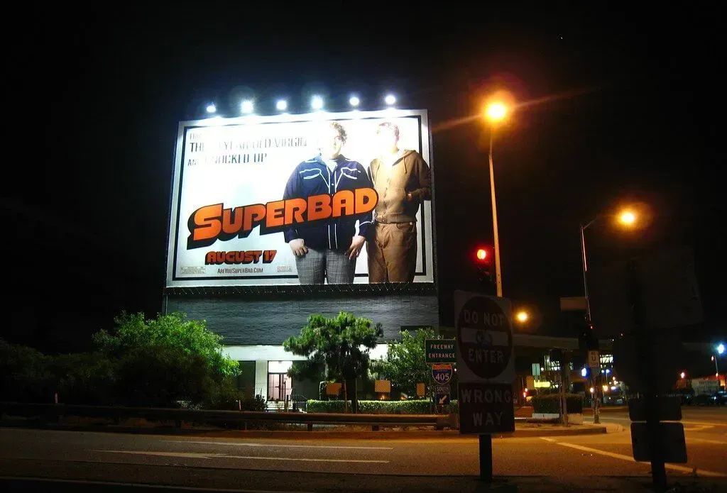 A billboard for superdad is lit up at night