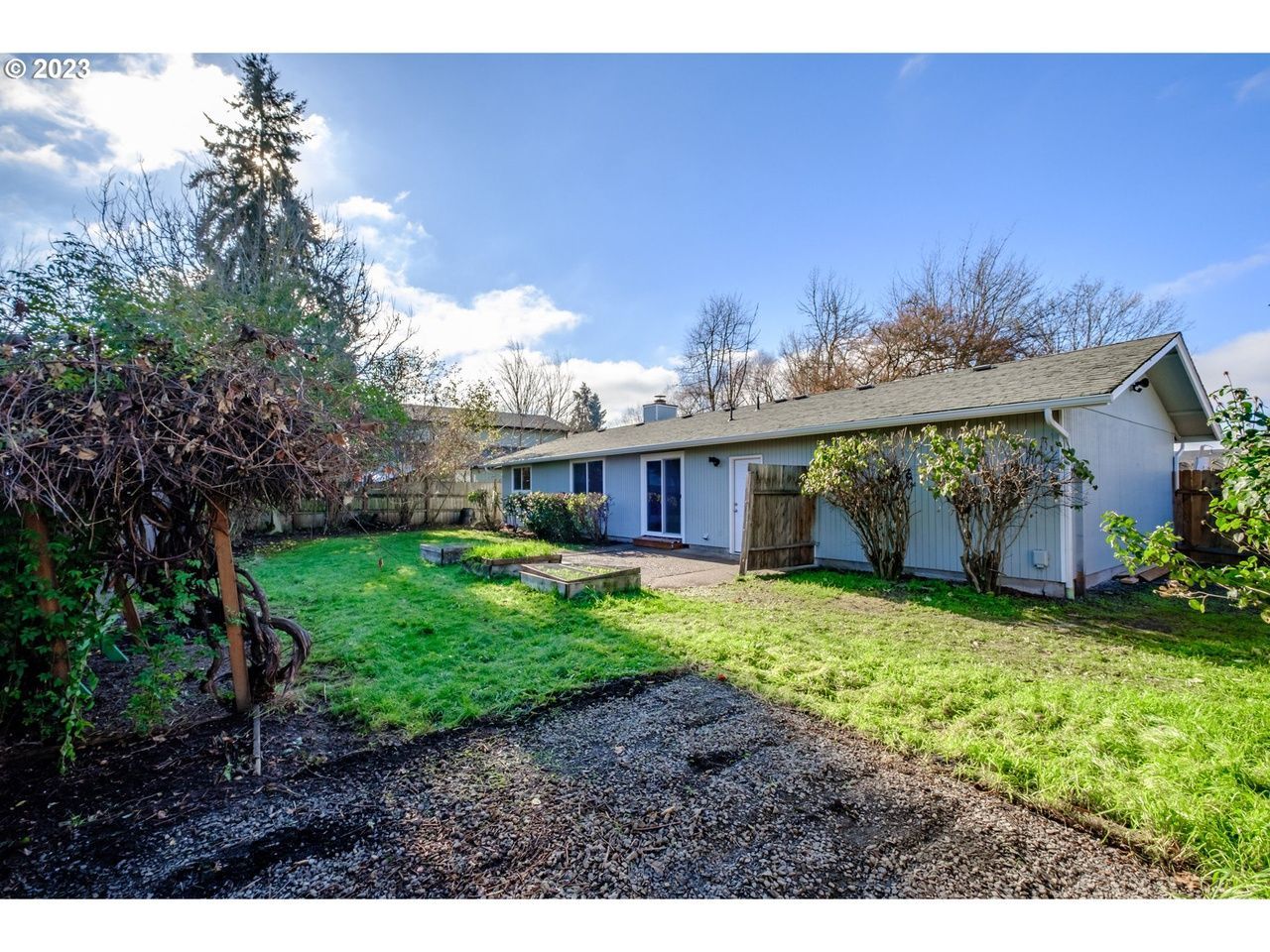 A white house with a large lawn in front of it.