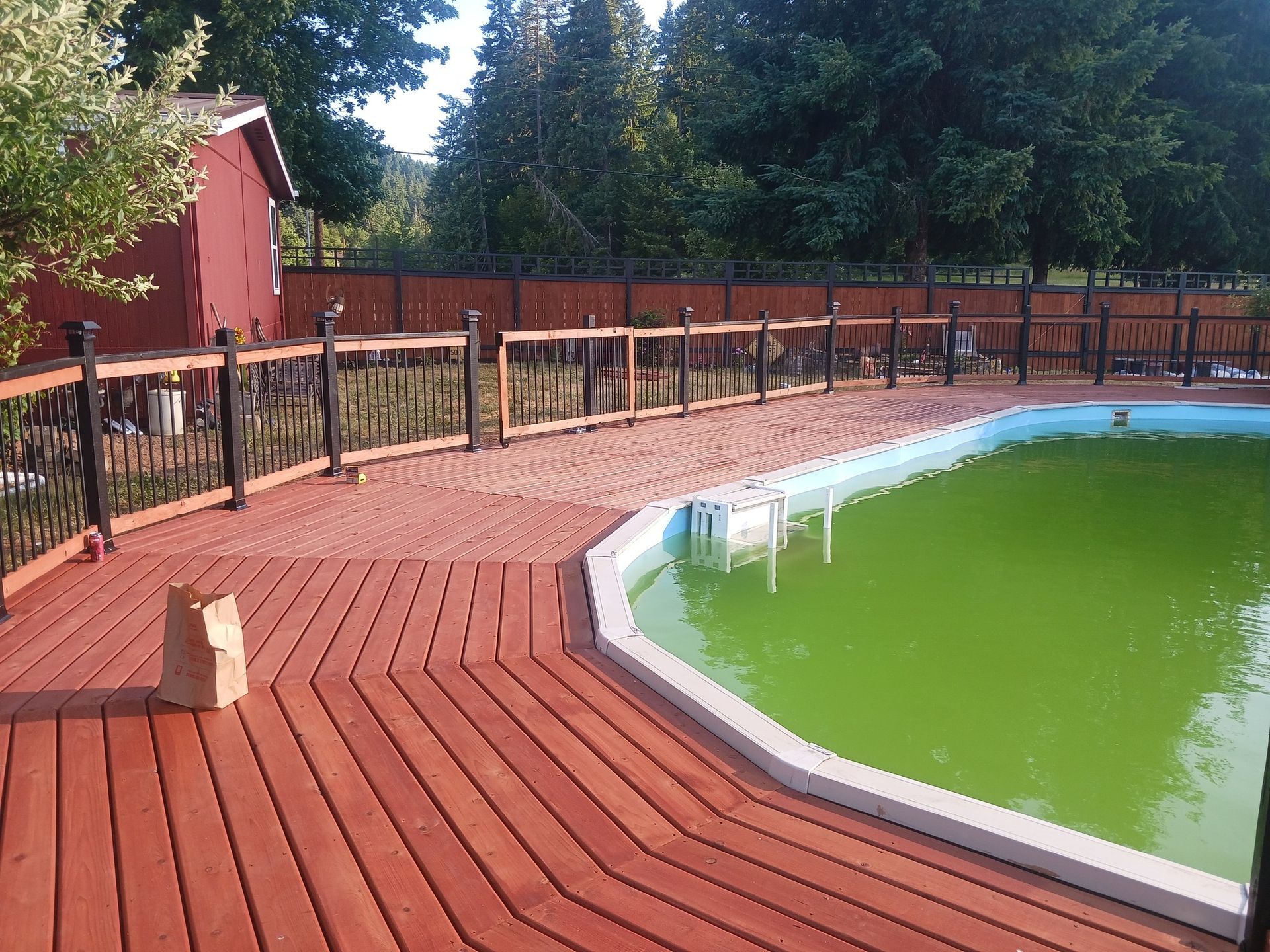 A large swimming pool with a wooden deck surrounding it