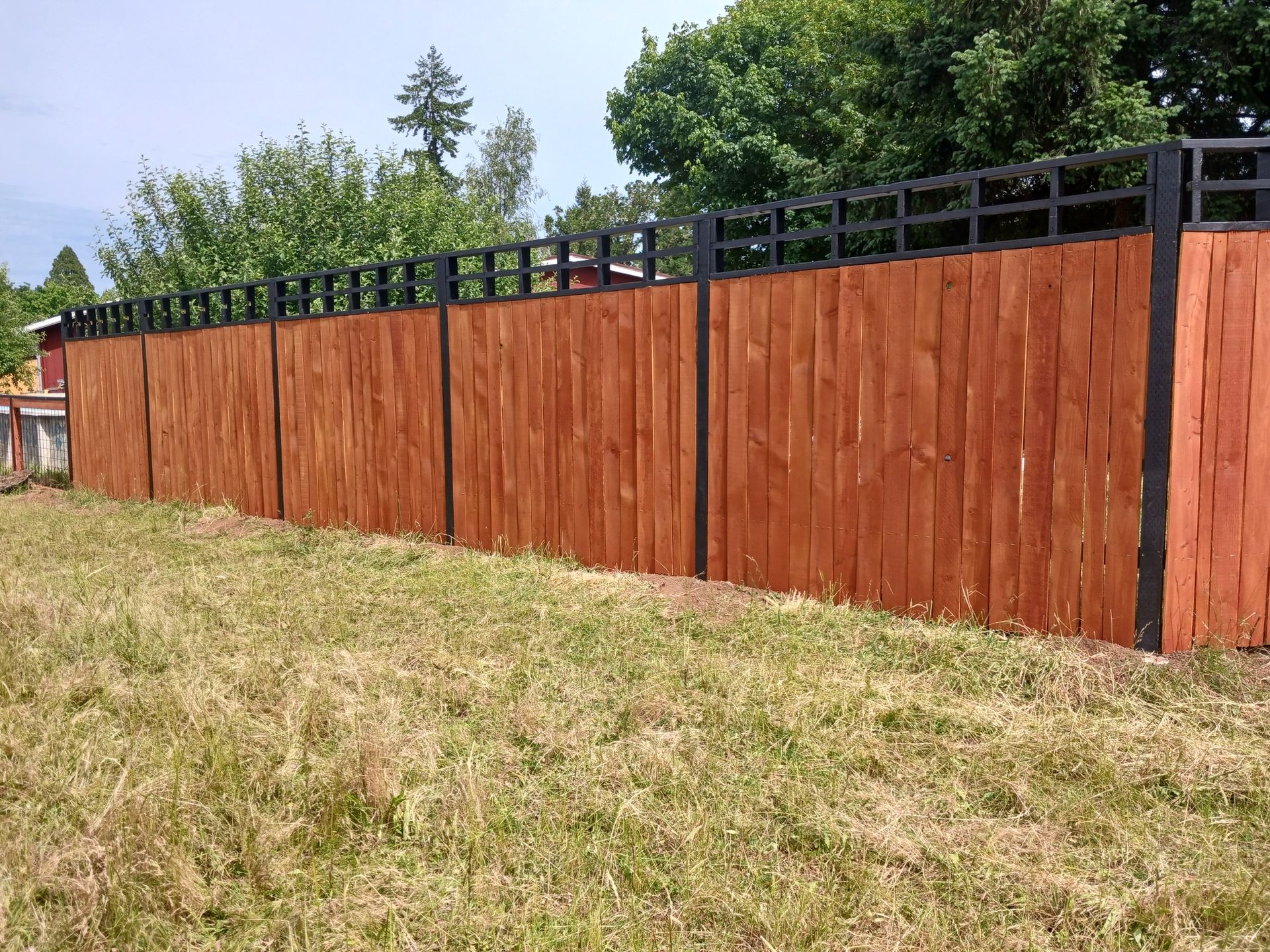 A wooden fence is sitting in the middle of a grassy field.