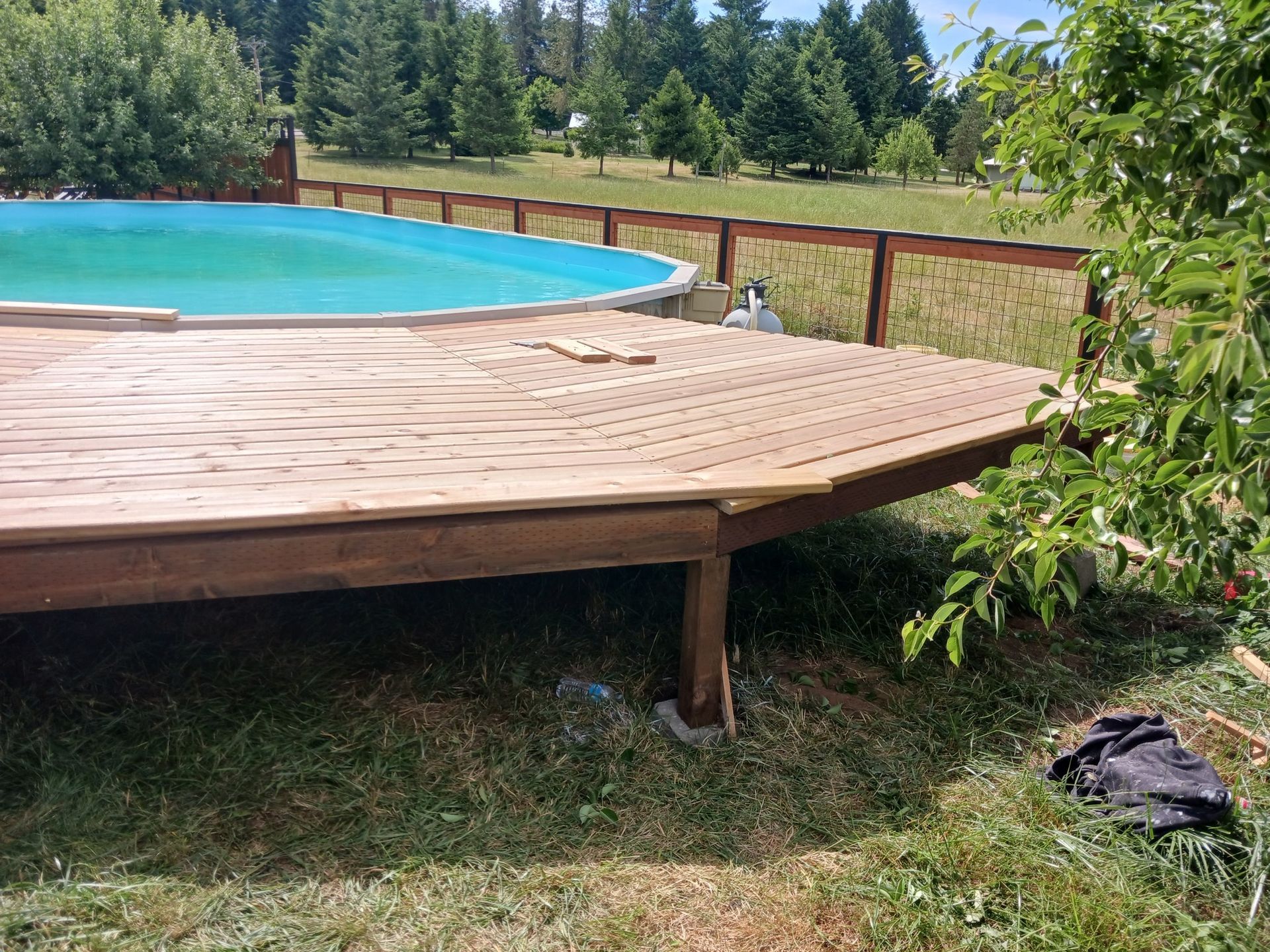A large swimming pool is surrounded by a wooden deck.