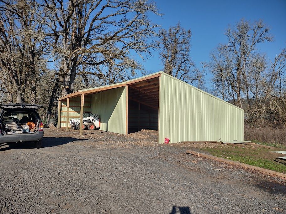 A truck is parked in front of a metal building.