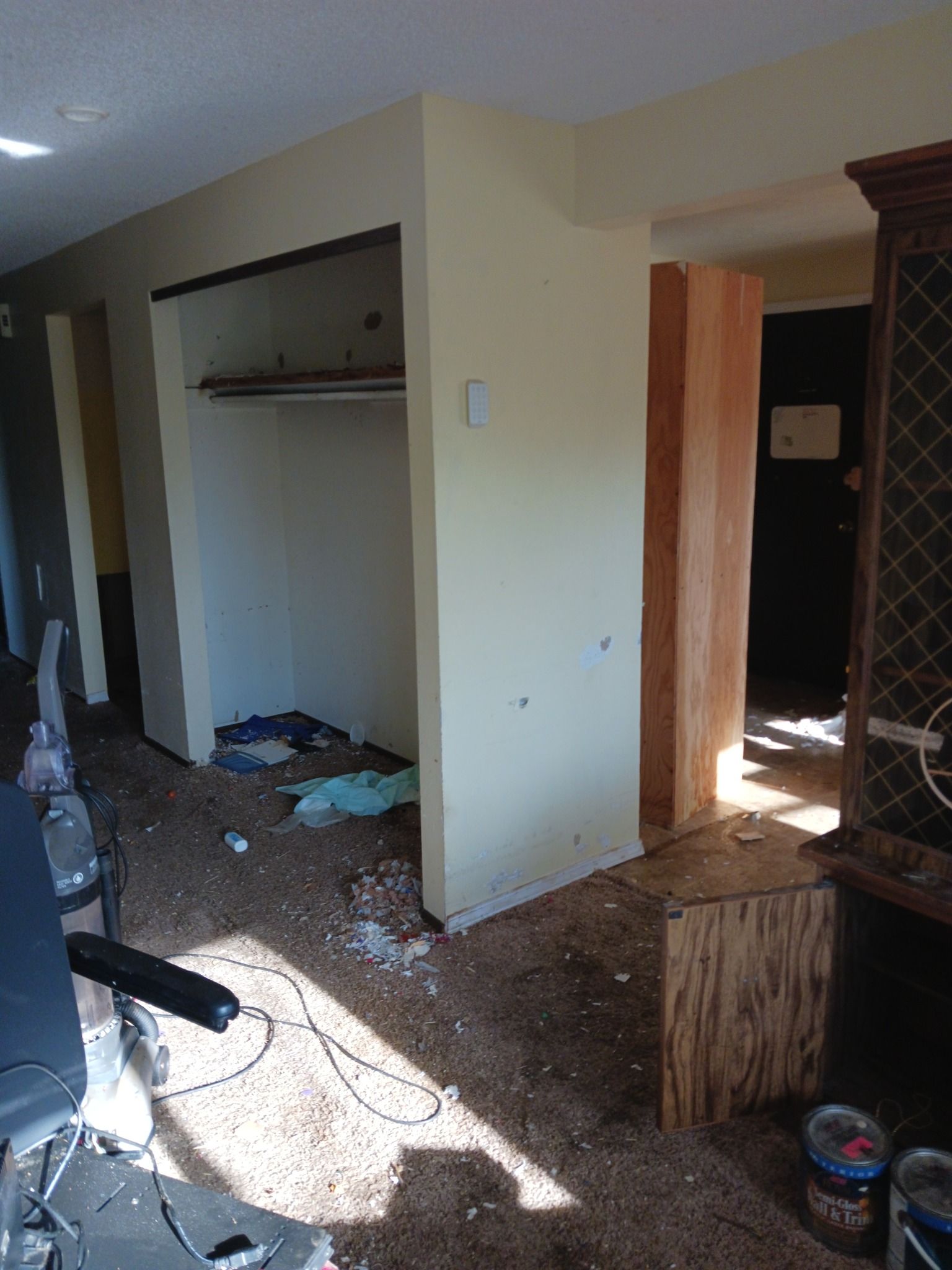 A living room with a closet and a chair in it.