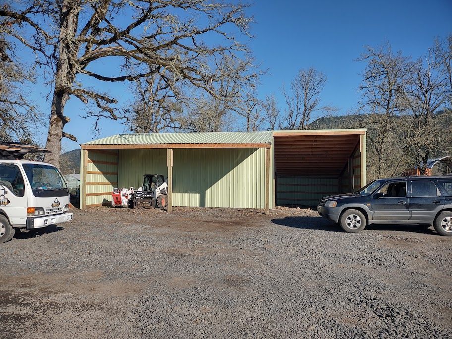 A white van and a gray suv are parked in front of a building.