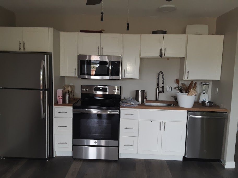 A kitchen with stainless steel appliances and white cabinets