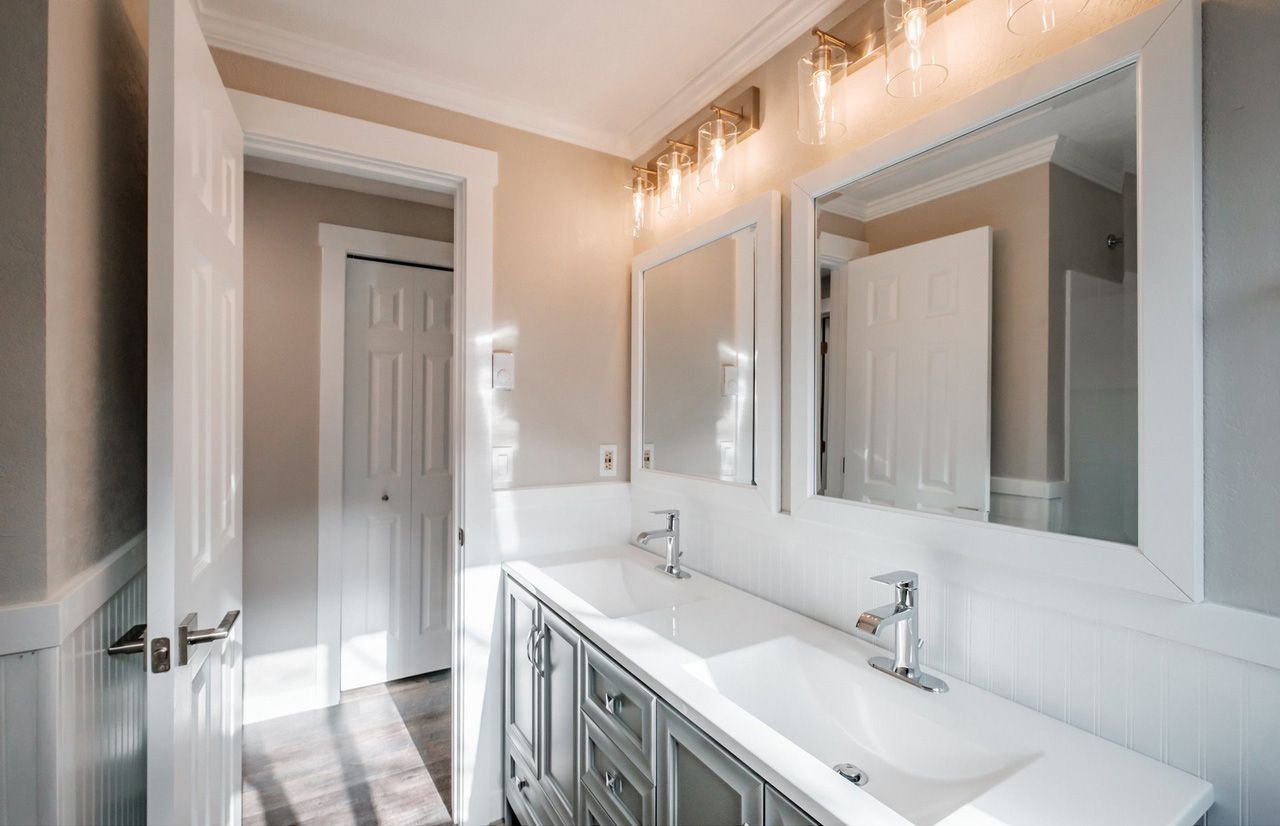 A bathroom with two sinks and two mirrors.