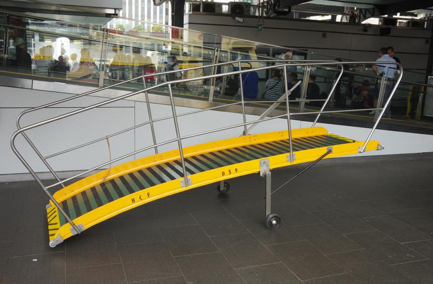 A yellow and green gangway with a metal railing