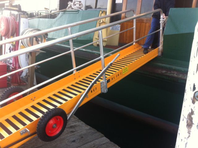 A yellow and black striped gangway with a red wheel